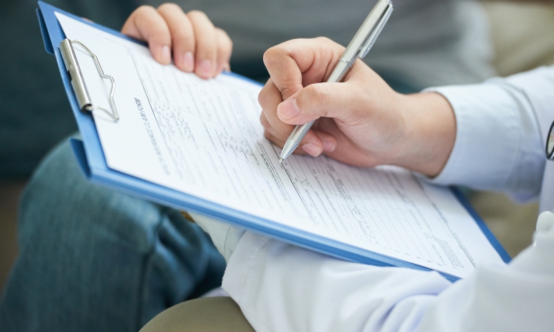 hands-of-unrecognizable-female-doctor-filling-in-form-on-clipboard (1)